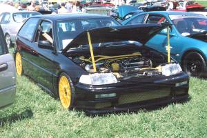 a car at a carshow that has various powder coated parts